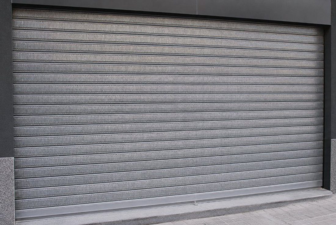 Cierre metálico microperforado bajado en un local comercial